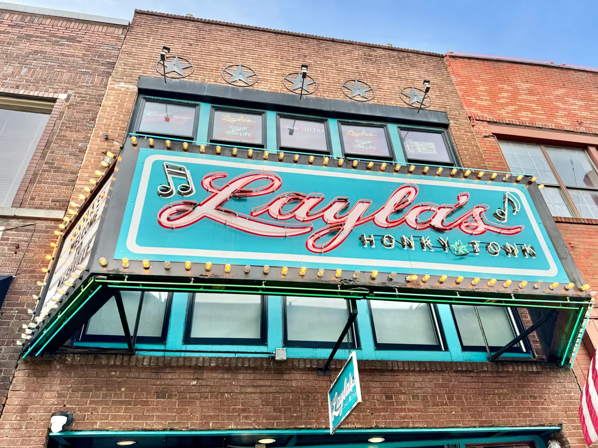 Turquoise Layla's Honky Tonk sign on its brick Broadway storefront